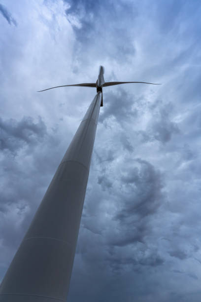 istock Wind turbine generating green energy under stormy sky 2202524381