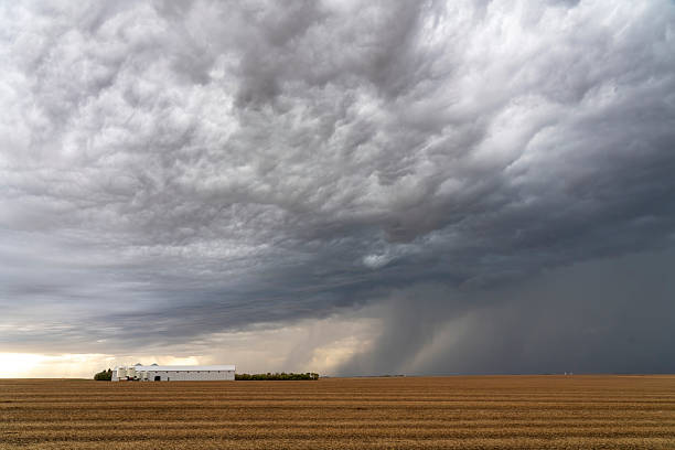 Dark storm clouds gathering over farm in saskatchewan canada