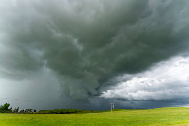 istock Dark storm clouds gathering over green field 2202526642