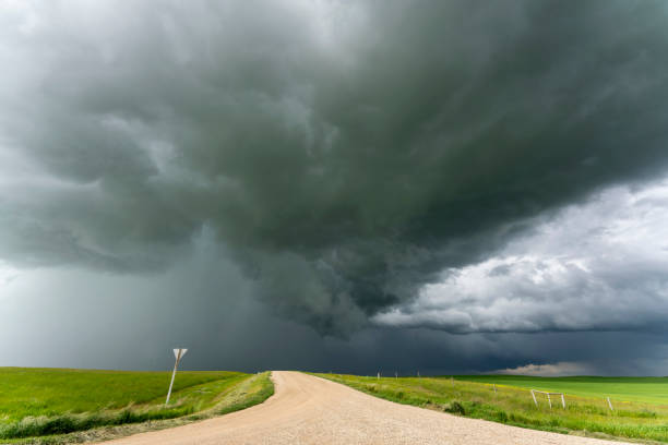 istock Gravel road disappearing under a dramatic supercell storm cloud 2202526664