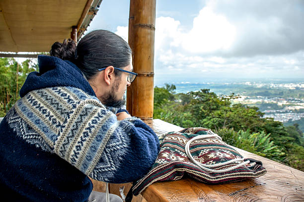 Thoughtful man wearing glasses and wool sweater in rustic setting