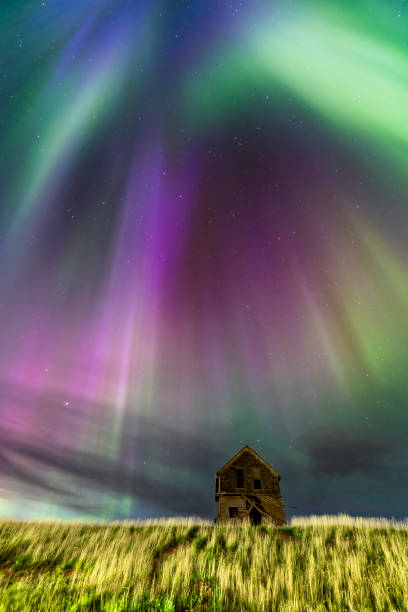 istock Abandoned house under majestic aurora borealis illuminating night sky 2202528087