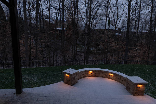 istock Snow-Covered Patio with Lit Stone Wall 2202530412