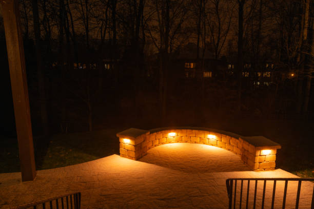 Illuminated Patio with Stone Wall at Night