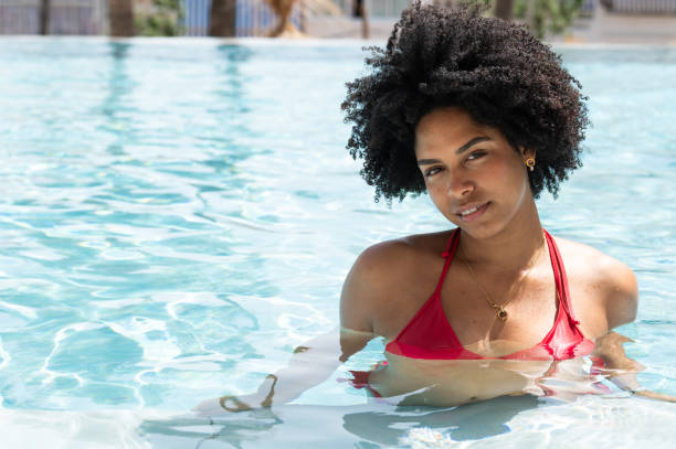 istock Young woman relaxing in a swimming pool during summer vacation 2202531737