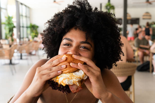 istock Woman enjoying a delicious burger in a restaurant 2202531825