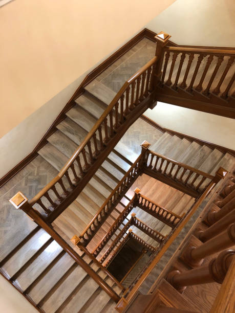 istock Square wooden spiral staircase in the library 2202532948