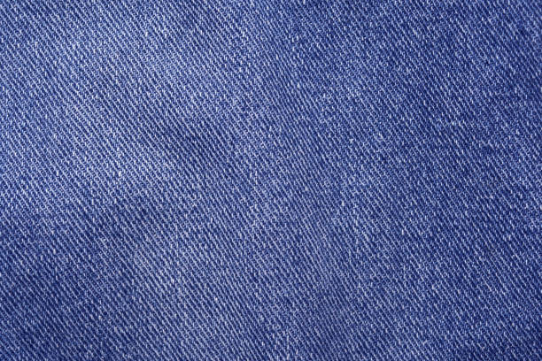 Close-up texture of blue denim fabric with detailed weave pattern in high resolution for fashion and design inspiration.
