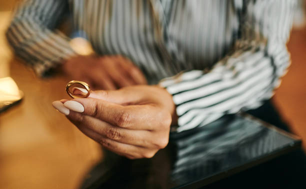 istock Woman Holding Wedding Ring in Hand 2202535810