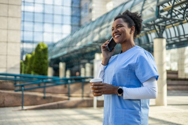 istock Smiling doctor making a phone call during coffee break outside hospital 2202537344