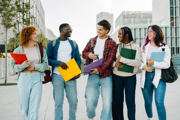 istock Group of diverse university student friends walking going to classes on college campus. Diversity in school and education 2202537564