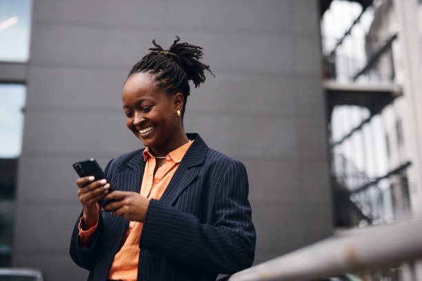 istock Smiling businesswoman using smartphone in urban setting 2202543162