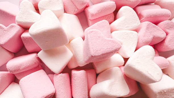 istock Pink heart-shaped marshmallow for Valentine's Day as a background and texture. Background with zifirs with a place for text, hearts are scattered 2202543190