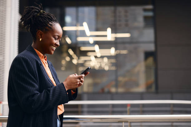 istock Smiling businesswoman using smartphone in modern office building 2202543194