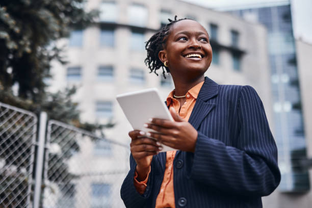 istock Smiling businesswoman using digital tablet in urban setting 2202543273
