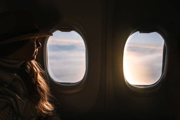 istock Female Tourist Looking Out the Airplane Window 2202546471