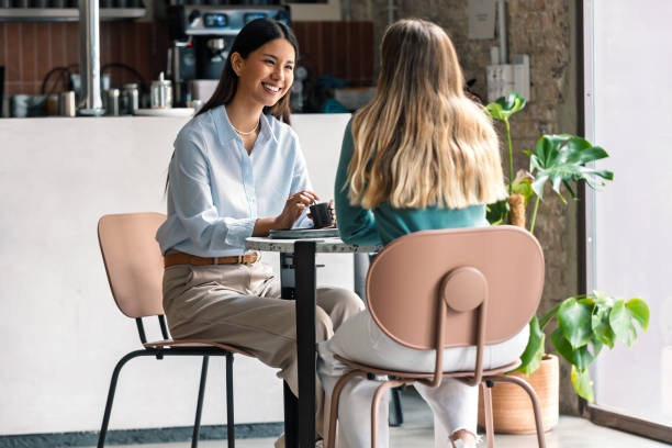 Beautiful women friends talking while having breakfast in a coffee shop