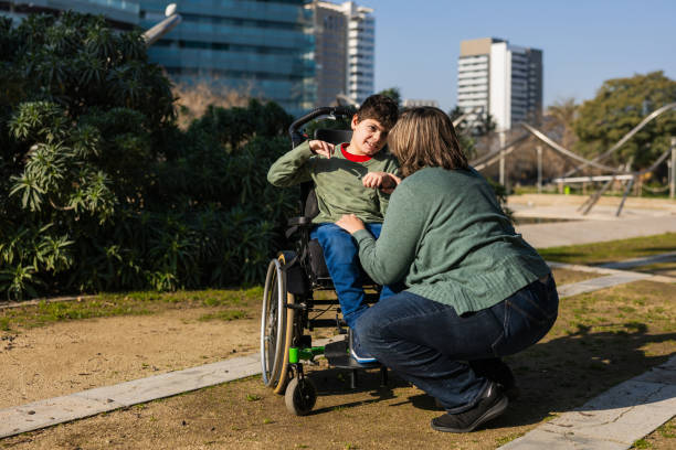 istock Mother playing with son in wheelchair at park 2202552970