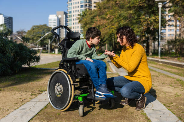 istock Mother playing with son in wheelchair in park 2202552986