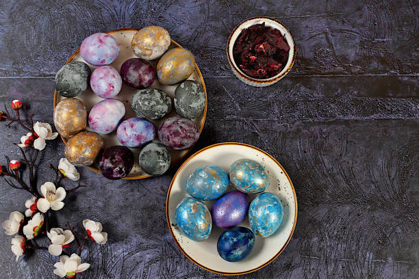 istock Easter celebration concept, Easter marble eggs dyed with natural hibiscus tea with sakura branch on concrete gray background. holiday card and ideas for preparing for the great holiday 2202553166