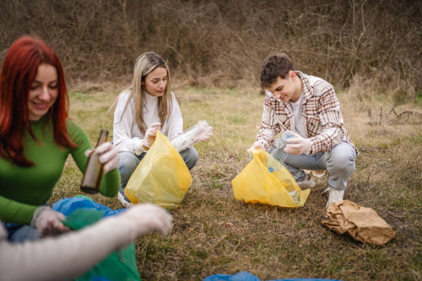 istock group of teenage friends pick up waste garbage plastic bottles 2202556708