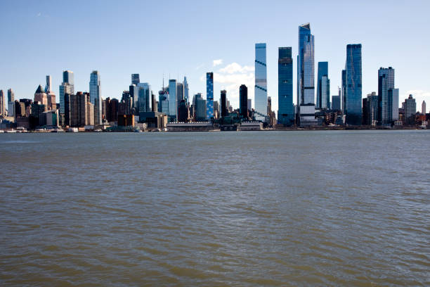 New York skyline, skyscrapers and buildings Hudson River in foreground.