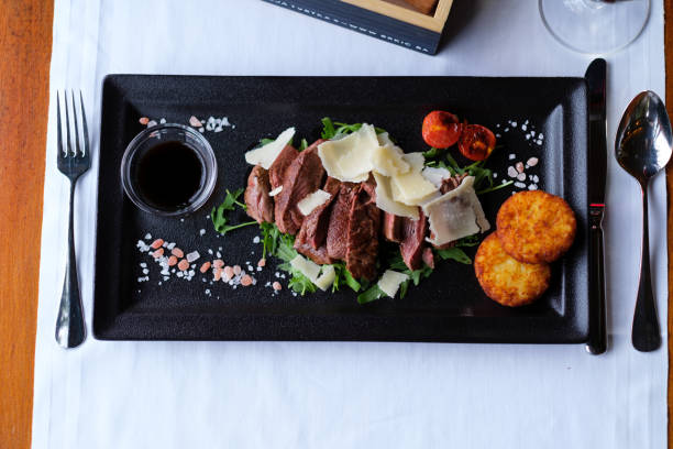 istock Sliced meat dish with cheese greens and potato cakes 2202561066