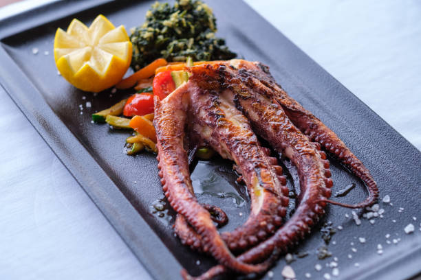 istock Grilled octopus with roasted vegetables and lemon 2202561114
