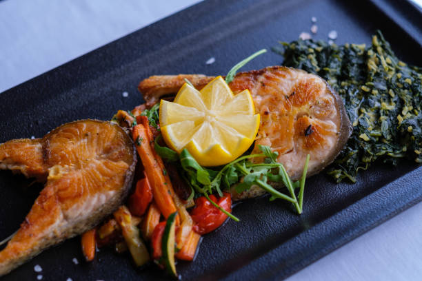istock Pan seared fish fillet with roasted vegetables and spinach 2202561129