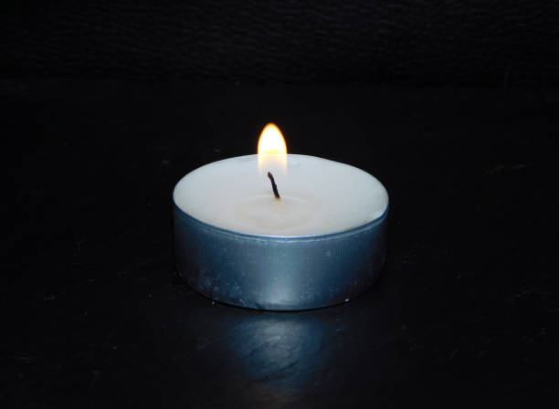 istock candle in the dark with flame 2202561159