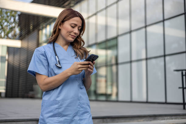 istock Female doctor using mobile phone outside hospital building 2202568653
