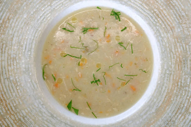 istock Creamy soup garnished with fresh herbs served in a textured bowl 2202569337