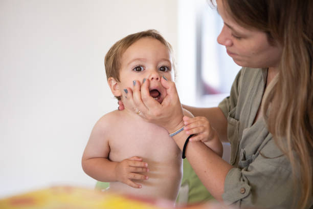 istock Young mother wiping snot from her baby's nose 2202571567