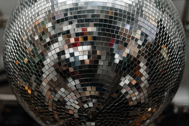 istock disco ball with mirror surface and bright rays, hanging on ceiling, night party background 2202573979