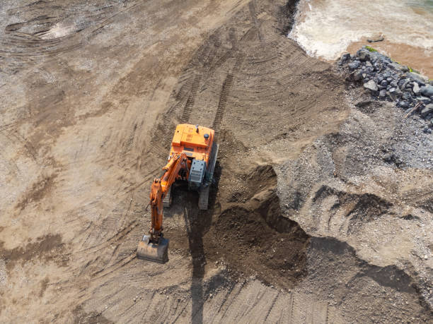 istock Drone view of a working yellow excavator on the seashore, river or dam. 2202585446