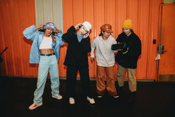 istock Cool dancers are having fun dancing against an orange wall 2202587189