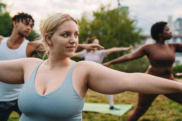 istock A multiethnic group of people is practicing yoga in a public park at sunset 2202587265