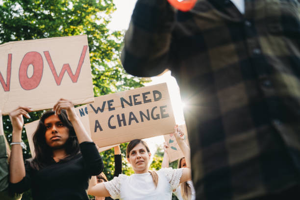 istock A group of climate activists are marching together holding signs 2202587300