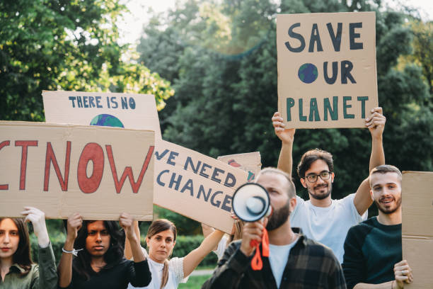 istock A group of climate activists are marching together holding signs 2202587328