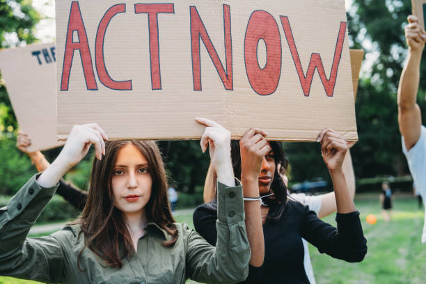 istock A group of climate activists are marching together holding signs 2202587330