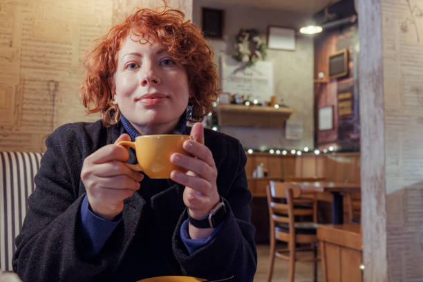 istock Woman warming up with coffee in illuminated restaurant 2202588410