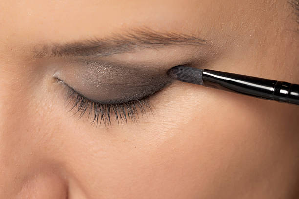 istock woman applying ceyeshadow with a brush. 2202589870