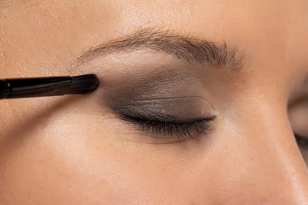istock woman applying ceyeshadow with a brush. 2202589873