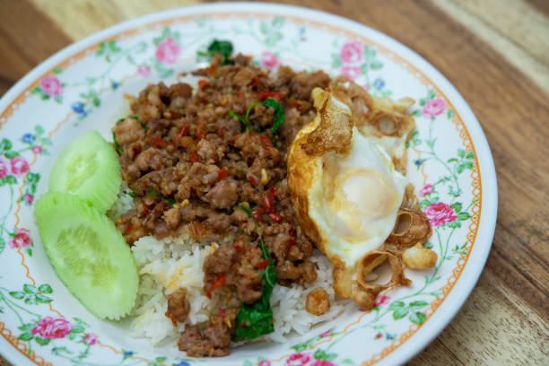 Rice topped with stir-fried pork or beef and basil for sale at Thai street food market or restaurant in Bangkok Thailand