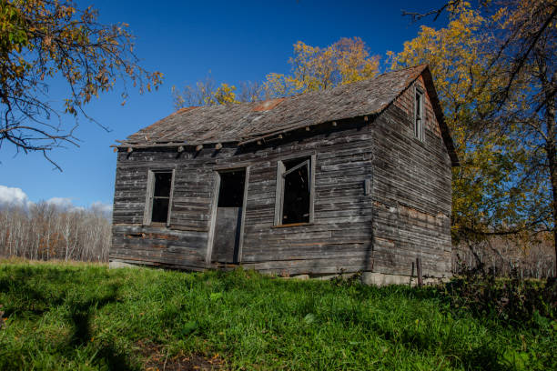 An old abandoned home sitting in a field.