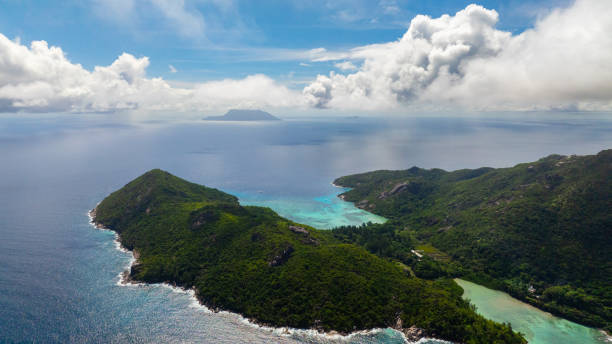 istock Island surrounded by turquoise waters under a cloudy sky. Seychelles, Mahe. 2202599216