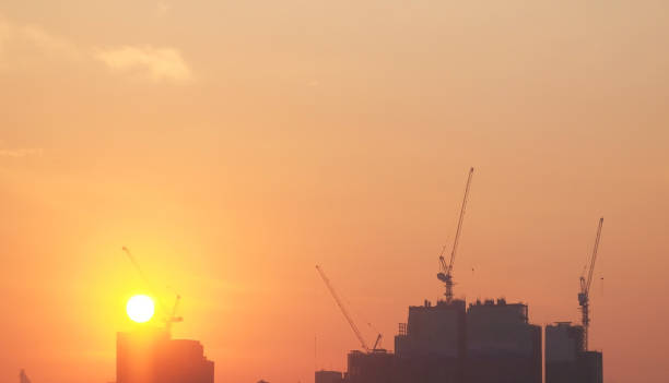 istock silhouette of construction site with crane and building in sunset time 2202613515