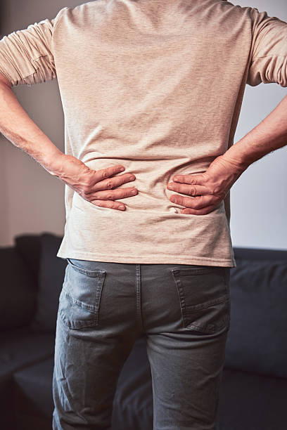 istock Man with hip, back and sciatica pain at home. 2202615694