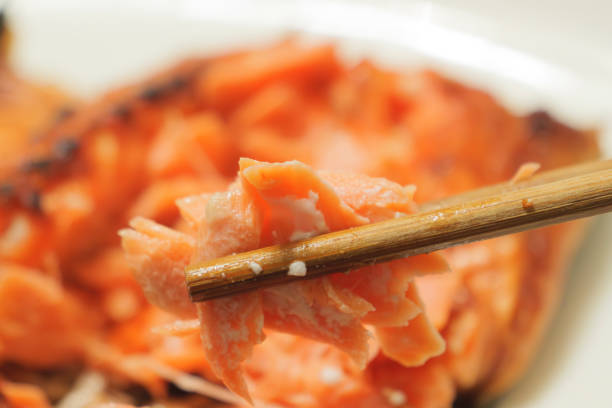Trying to eat grilled salmon with chopsticks.