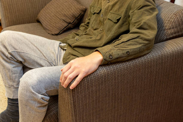 istock A man sitting on a sofa with his arm resting on the armrest 2202620906
